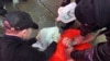 FILE - Demonstrators from the group 'World Can't Wait' hold a mock waterboarding of a prisoner.