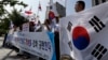 South Korean protesters shout slogans as they hold national flags during a press conference against abrupt cancellation by North Korea of planned reunions for families separated by the Korean War, Sept. 23, 2013.