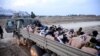 Israeli soldiers stand by a truck packed with shirtless Palestinian detainees, amid the ongoing conflict between Israel and the Palestinian Islamist group Hamas, in the Gaza Strip Dec. 8, 2023. 