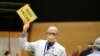 FILE - Dr. John Corman, the chief clinical officer for Virginia Mason Franciscan Health, holds a sign that reads "Need Vaccine" to signal workers to bring him more doses of the Pfizer vaccine for COVID-19, Jan. 24, 2021.