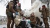Medical workers treat a wounded local resident at a site of residential buildings heavily damaged during a Russian missile attack, amid Russia's attack on Ukraine, in Kharkiv, Ukraine Jan. 23, 2024.