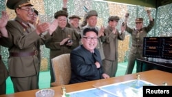 북한 노동신문이 지난 23일 '중장거리 전략탄도로케트 화성-10'(무수단 미사일) 시험발사 성공 소식을 게재하며 관련 사진을 수십장 공개했다. 미사일 발사를 지켜보는 김정은 노동당 위원장과 군 간부들이 환호하고 있다. (자료사진)