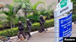 FILE - Kenya Defense Force soldiers run to take their positions at the Westgate shopping center, on the fourth day since militants stormed into the mall, in Nairobi, Sept. 24, 2013. 