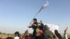 FILE - Taliban fighters greet residents in the Surkhroad district of Nangarhar province, east of Kabul, Afghanistan, June 16, 2018. 