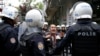 FILE - A woman argues with riot police as they detain protesters during a demonstration against the arrest of Nuriye Gulmen and Semih Ozakca, who are on hunger strike protest, in Ankara, Turkey, May 22, 2017.