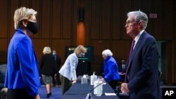ARCHIVO - La senadora Elizabeth Warren, demócrata por Massachusetts, habla con el presidente de la Reserva Federal, Jerome Powell, antes de una audiencia de la Comisión de Banca, Vivienda y Asuntos Urbanos del Senado, el 28 de septiembre de 2021.