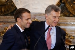 El presidente de Francia, Emmanuel Macron (izq.) y el presidente de Argentina, Mauricio Macri, sonríen al final de una conferencia de prensa conjunta en el palacio presidencial argentino, en Buenos Aires. 29 de noviembre de 2018.