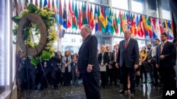 El secretario de Estado Rex Tillerson, acompañado por el subsecretario de Asuntos Políticos del Departamento de Estado, Tom Shannon, frente a una placa conmemorativa en el vestíbulo del Departamento de Estado que honra a los empleados que han dado su vida en cumplimiento del deber.