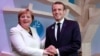 German Chancellor Angela Merkel and French President Emmanuel Macron hold hands after leaving books at the peace library at the Paris Peace Forum as part of the commemoration ceremony for Armistice Day, 100 years after the end of World War I, in Paris, Nov. 11, 2018.