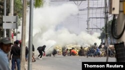 Los maniffestantes se protegen detrás de una barricada improvisada en Mandalay, Myanmar, donde las fuerzas militares han causado la muerte de más de 130 personas, según datos de la ONU.
