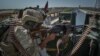 FILE - A security personnel stands guard on top of a vehicle outside United Nations Assistance Mission in Afghanistan (UNAMA) office compound in Guzara district of Herat province, July 31, 2021.