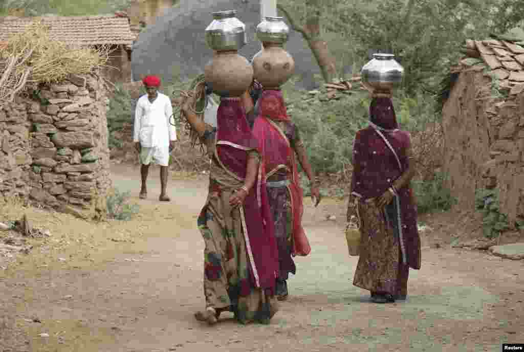 Para perempuan India membawa bejana berisi air minum di desa Devmali, Rajasthan, India.