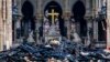 A view of the cross and sculpture of Pieta by Nicolas Coustou in the background of debris inside Notre Dame, in the aftermath of a fire that devastated the cathedral in Paris, France, April 16, 2019. 