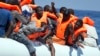 FILE - Migrants wearing life vests float in an inflatable boat during a rescue operation from the Aquarius vessel of SOS Mediterranee NGO and MSF (Doctors Without Borders) in the sea some 25 Nautical miles (29 miles, 46 kilometers) north of the Libyan coast, Aug. 27, 2017.