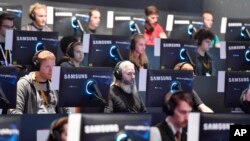 FILE - Visitors try out the latest video games at the Gamescom fair for computer games in Cologne, Germany, Aug. 22, 2017. The World Health Organization is adding Gaming disorder to the section on Mental and Addictive Disorders in its new International Classification of Diseases.