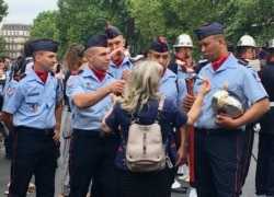 A woman talks to French forces after the Bastille Day parade, in Paris, France, July 14, 2019. (L. Bryant/VOA)