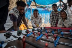 Un niño sonríe después de marcar un gol mientras jugaba al futbolín en la calle contra otros niños y jóvenes, cuando los cristianos ortodoxos etíopes celebran el domingo de Pascua, en Gondar, en la región de Amhara de Etiopía, el 2 de mayo de 2021.
