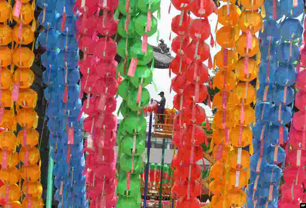 Seorang pekerja menurunkan lentera-lentera usai perayaan kelahiran Buddha di kuil Chogye, Seoul, Korea Selatan.&nbsp;