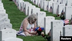 Una mujer visita la tumba de su hijo en el Cementerio Nacional de Arlington el 29 de mayo de 2022.