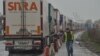 A driver walks next to trucks stuck in a traffic jam due a strike by customs agents, a few kilometers from the entrance to the Channel tunnel, in Loon-Plage, near Dunkirk, northern France, March 6, 2019.