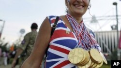 Una aficionada británica camina por el Olympic Park de Londres llevando colgadas medallas de chocolate antes de la Ceremonia de Clausura.