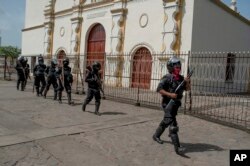 La policía nicaragüense fuertemente armada toma posiciones antes de la llegada del presidente Daniel Ortega, en Masaya, Nicaragua, el viernes 13 de julio de 2018.