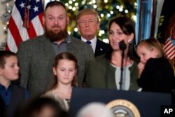 El presidente de EE.UU. Donald Trump con una de las familias invitadas a la Casa Blanca para destacar cómo el acuerdo de reforma impositiva alcanzado en el Congreso beneficiará a la clase media. Dic. 13, 2017.