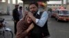 A man comforts a Christian woman who lost her husband in a deadly shooting incident, outside a hospital in Quetta, Pakistan, April 15, 2018.