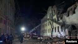 Rescatistas y agentes de policía trabajan en el lugar de un edificio residencial gravemente dañado por un ataque con misiles rusos, en medio del ataque de Rusia contra Ucrania, en Kharkiv, Ucrania, el 17 de enero de 2024. REUTERS/Vitalii Hnidyi