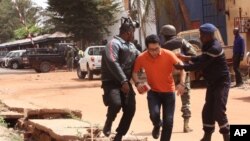 Tropas malienses ayudan a un rehén que se escapó del hotel Radisson Blu atacados por yihadistas aparentemente pertenecientes a un grupo afiliado a al-Qaeda.