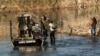 Una familia migrante es recogida por un miembro del Departamento de Seguridad Pública de Texas después de quedar varada en la orilla del río durante horas, en Eagle Pass, Texas, el 18 de enero de 2024.