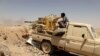 FILE - A Yemeni government fighter fires a vehicle-mounted weapon at a frontline position during fighting against Houthi fighters in Marib, Yemen, March 28, 2021.