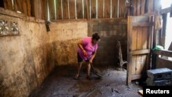 Una mujer limpia su casa del lodo que se originó por el desbordamiento del río después de que el huracán Julia azotara y arrojara fuertes lluvias en La Cruz, Nicaragua, el 10 de octubre de 2022.