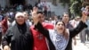 A mother holds her hands up as she escorts her son from the al-Fath mosque in Cairo August 17, 2013. Gunmen opened fire on security forces from a second floor window in the Fath mosque, where hundreds of Mursi supporters have been taking refuge since prot