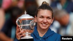 Romania’s Simona Halep celebrates with the trophy after winning the French Open final against Sloane Stephens of the U.S. at Roland Garros, Paris, June 9, 2018. 