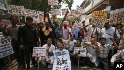 FILE - Protestors shout slogans against the recent Walmart-Flipkart deal in New Delhi, India, May 12, 2018. Walmart is paying $16 billion for a controlling stake in Flipkart, breaking into a fast-growing economy where it has struggled to establish a foothold.