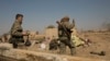 A U.S.-backed Syrian Democratic Forces (SDF) fighter watches illumination rounds light up Baghuz, Syria, as the last pocket of Islamic State militants is attacked, March 12, 2019. 