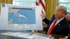 President Donald Trump talks with reporters after receiving a briefing on Hurricane Dorian in the Oval Office of the White House, in Washington, Sept. 4, 2019. The projected path of the hurricane appears to have been extended with a black felt marker.