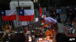 Chilenos dejan velas, flores y banderas frente a la casa del expresidente Sebastián Piñera en Santiago, el 6 de febrero de 2024.
