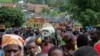 FILE - Refugees from the Democratic Republic of Congo carry their belongings as they walk near the United Nations High Commissioner for Refugees (UNHCR) offices in Kiziba refugee camp in Karongi District, Rwanda, Feb. 21, 2018.
