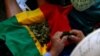 Una mujer manipula un manojo de hojas de coca sobre una bandera de Bolivia, durante la Cumbre de los Pueblos, celebrada en Santiago de Chile, el 27 de enero de 2013. El cultivo de esta planta es motivo de fricción entre Estados Unidos y Bolivia.
