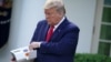 El presidente Donald Trump sostiene un dispositivo para realizar la prueba del nuevo coronavirus en 5 minutos de Abbott Laboratories durante su conferencia de prensa diaria en la Casa Blanca sobre COVID-19 el 30 de marzo de 2020.