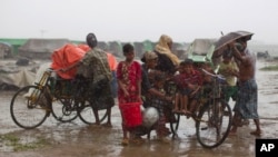 Internally displaced Rohingya people load rickshaws with children and belongings to leave their camp in Sittwe, northwestern Rakhine State, Burma, May 16, 2013.