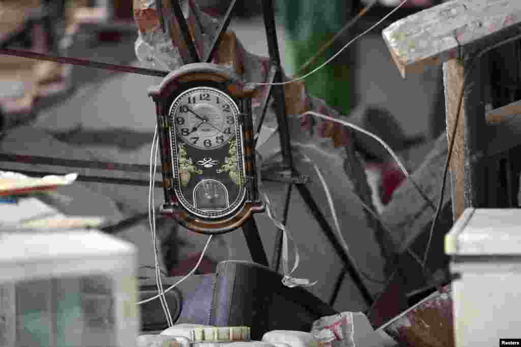 A clock is seen amidst the debris of a collapsed house after a strong 6.6 magnitude earthquake, at Longmen village, Lushan county, Ya&#39;an, Sichuan province, Apr. 20, 2013. 