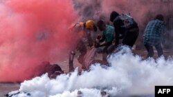 Protesters try to help injured people outside the Kenya Parliament during a nationwide strike to protest against tax hikes and the Finance Bill 2024 in downtown Nairobi, on June 25, 2024.