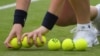 FILE - A ball boy with new tennis balls during a match between USA’s Coco Vandeweghe and Germany’s Mona Barthel, in Wimbledon, July 4, 2017. 