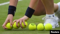 FILE - A ball boy with new tennis balls during a match between USA’s Coco Vandeweghe and Germany’s Mona Barthel, in Wimbledon, July 4, 2017. 