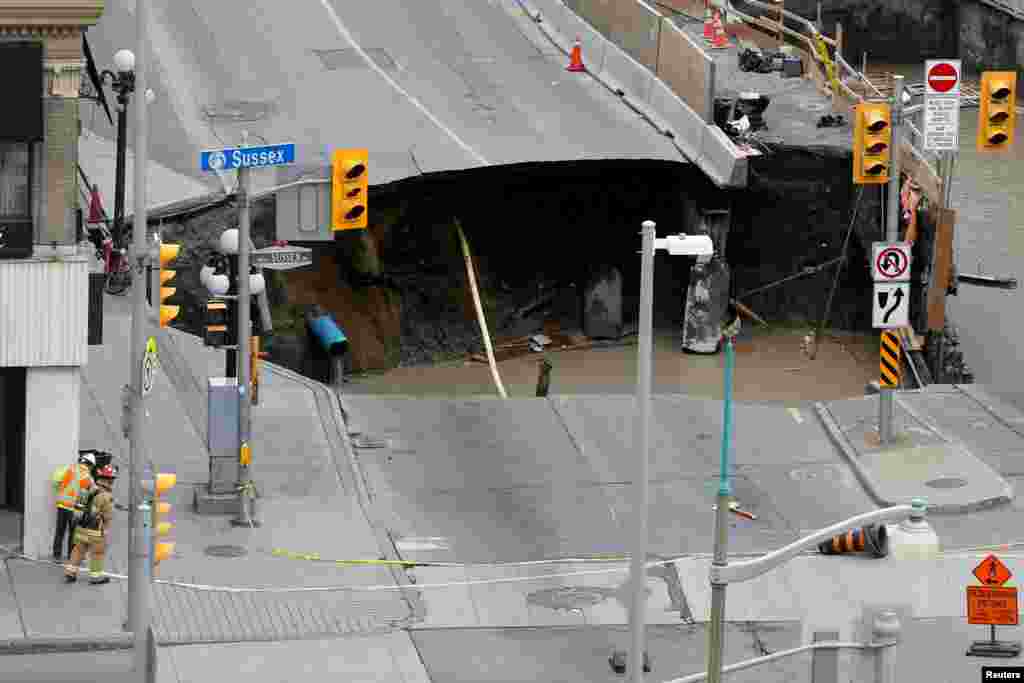 Para pekerja memeriksa jalanan yang ambles di Ottawa, Kanada.