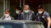 Oficiales de policía escoltan a Cheung Kim-hung, a la derecha, director ejecutivo de Next Digital Ltd, la empresa matriz del diario Apple Daily en Hong Kong, 17 de junio 2021.