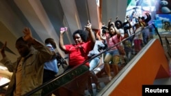 Un grupo de civiles escapa del centro comercial Westgate en Nairobi, Kenya, que sigue en manos de terroristas.